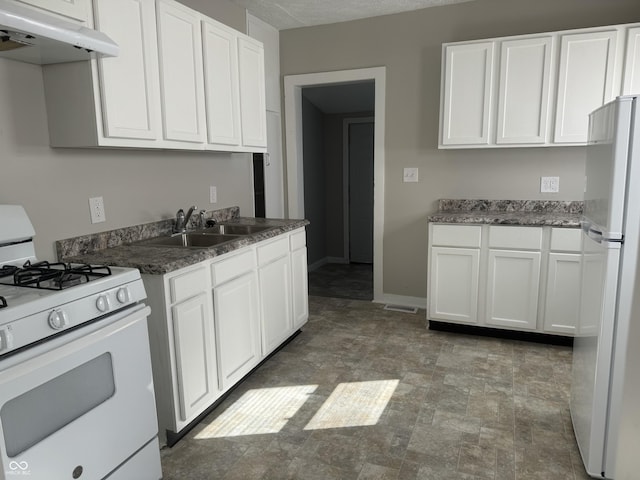 kitchen featuring white appliances, a sink, white cabinets, and under cabinet range hood