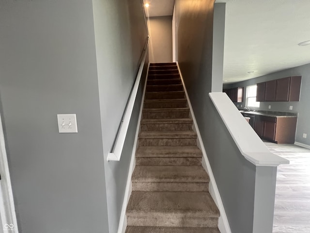 staircase with wood finished floors and baseboards