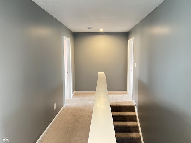 hall with light colored carpet and baseboards