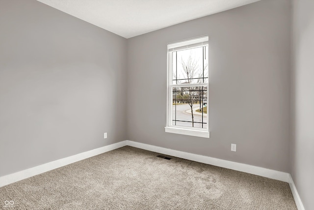 carpeted empty room with visible vents and baseboards