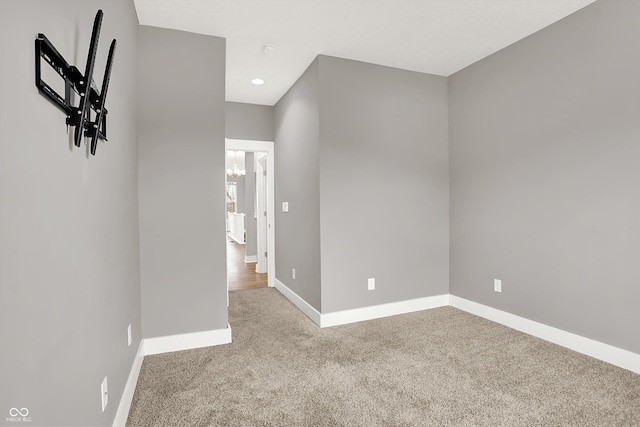 carpeted empty room featuring baseboards