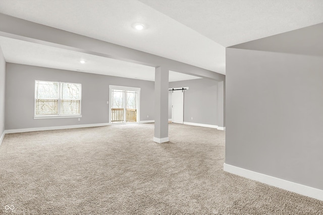 interior space featuring baseboards and a barn door