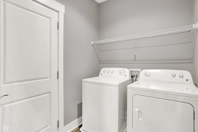 laundry room with laundry area, washing machine and dryer, and baseboards