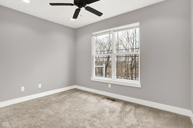 empty room featuring carpet, visible vents, ceiling fan, and baseboards