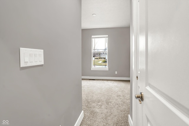 corridor with carpet flooring and baseboards