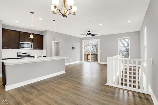 kitchen with dark brown cabinetry, baseboards, appliances with stainless steel finishes, and wood finished floors