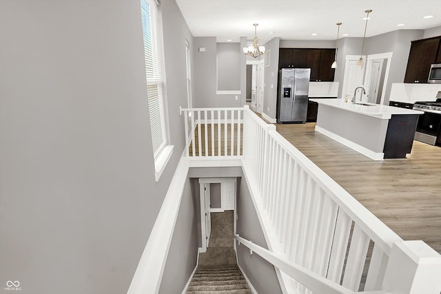 stairs with a notable chandelier and recessed lighting