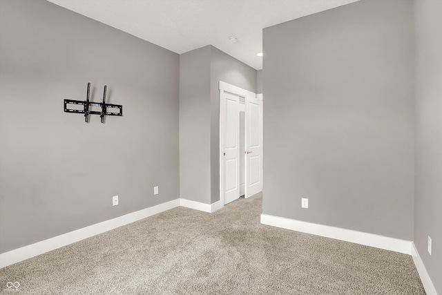 carpeted empty room featuring baseboards