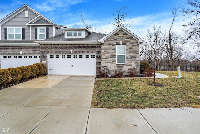 view of front of home with a front yard, roof with shingles, driveway, and brick siding