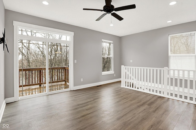 spare room with recessed lighting, wood finished floors, and baseboards