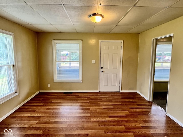 entrance foyer with wood finished floors, a paneled ceiling, and baseboards