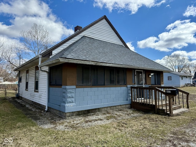 view of front of property featuring a shingled roof, a chimney, and fence