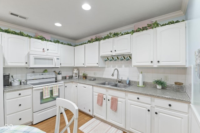 kitchen featuring visible vents, ornamental molding, light wood-style floors, a sink, and white appliances