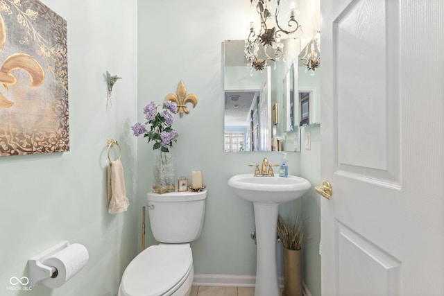 bathroom with toilet, baseboards, and a sink