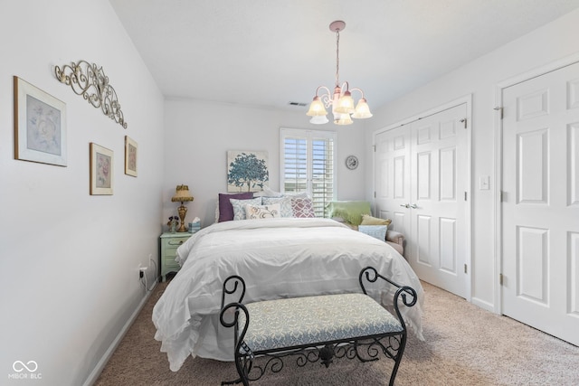 carpeted bedroom with a chandelier, a closet, visible vents, and baseboards