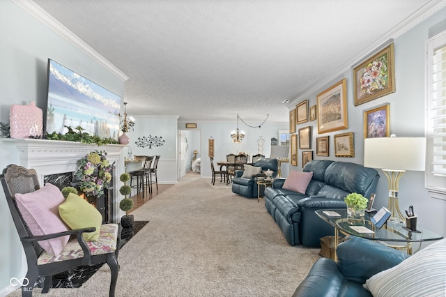 carpeted living room featuring a textured ceiling, a notable chandelier, a fireplace, ornamental molding, and plenty of natural light