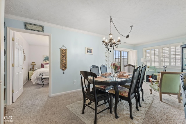 carpeted dining area featuring a notable chandelier, a textured ceiling, baseboards, and crown molding