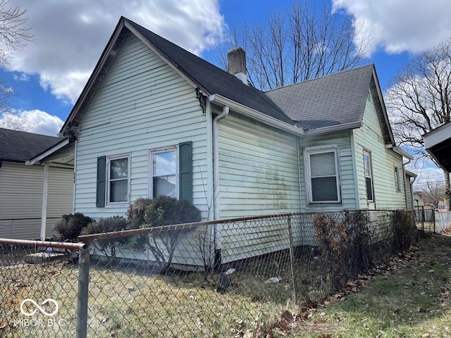 view of home's exterior featuring fence and a chimney