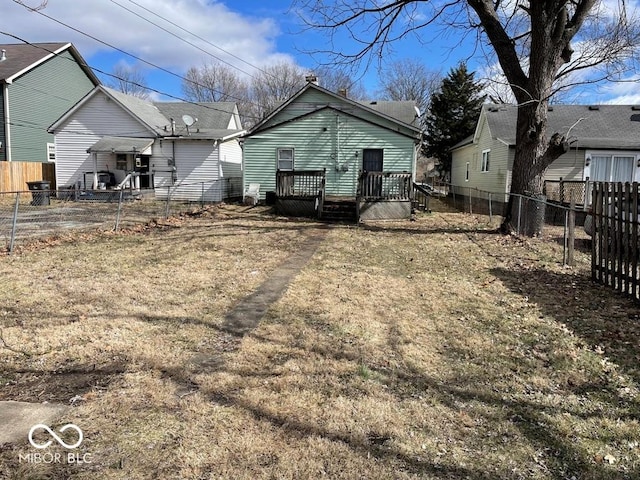 rear view of house with a fenced backyard