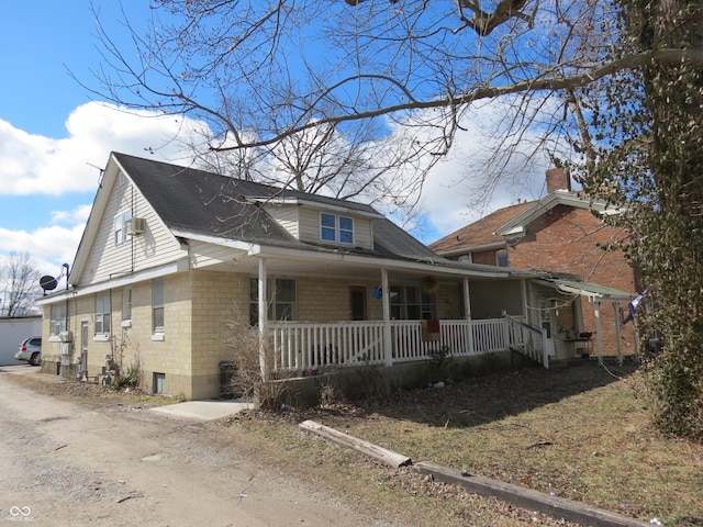 bungalow with covered porch and a shingled roof