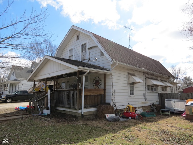 view of side of property featuring a shingled roof, a porch, and a gambrel roof