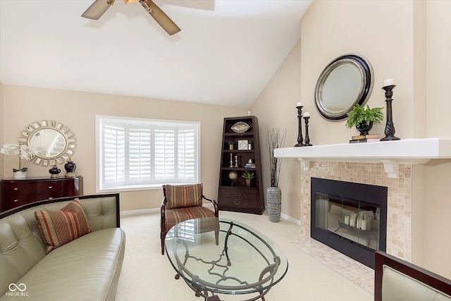 living area with baseboards, ceiling fan, vaulted ceiling, and a tile fireplace