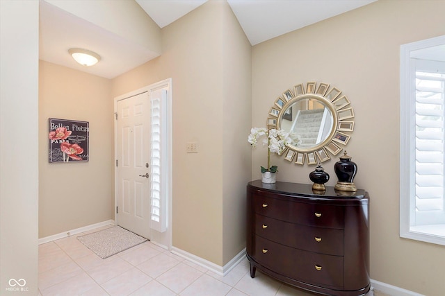 entryway with light tile patterned flooring and baseboards