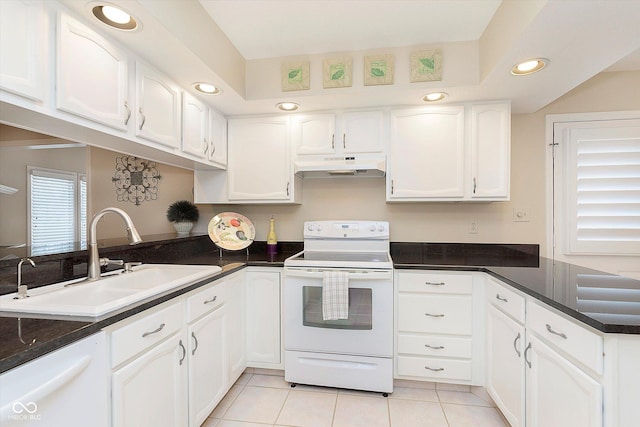 kitchen featuring white appliances, a peninsula, a sink, white cabinets, and under cabinet range hood