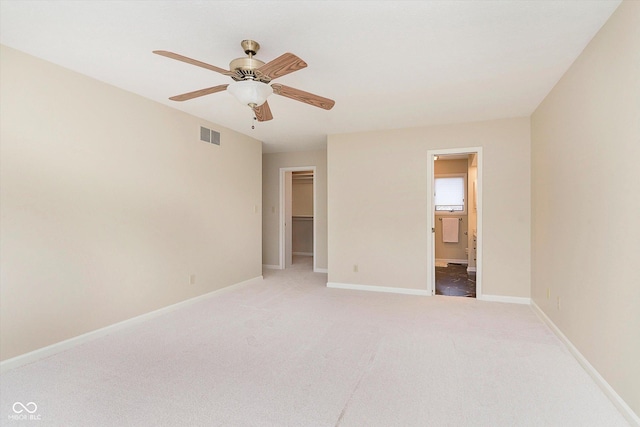 unfurnished bedroom with visible vents, baseboards, light colored carpet, and a spacious closet