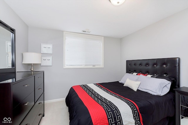 bedroom featuring visible vents, light colored carpet, and baseboards