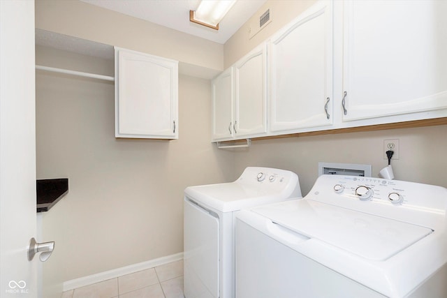 clothes washing area featuring visible vents, baseboards, light tile patterned floors, cabinet space, and separate washer and dryer