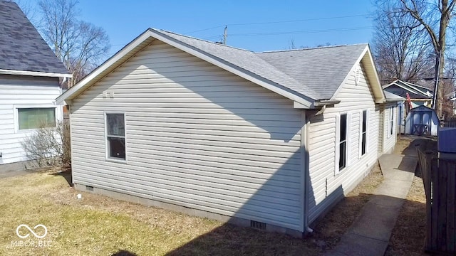 view of side of property featuring crawl space and roof with shingles