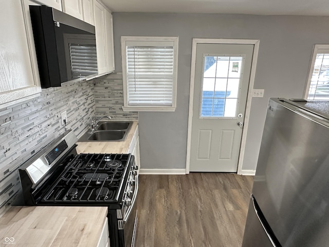 kitchen with white cabinets, a wealth of natural light, stainless steel appliances, and a sink