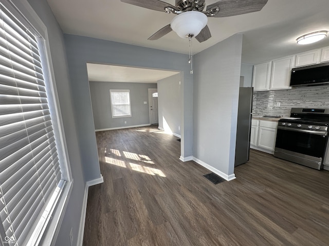 kitchen with visible vents, white cabinets, appliances with stainless steel finishes, dark wood-style floors, and tasteful backsplash