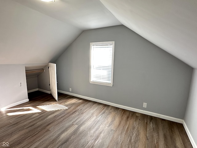 bonus room with lofted ceiling, baseboards, and dark wood finished floors