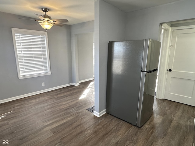 kitchen featuring ceiling fan, dark wood-style flooring, visible vents, baseboards, and freestanding refrigerator