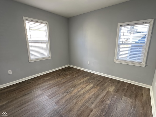 unfurnished room with dark wood-style floors and baseboards