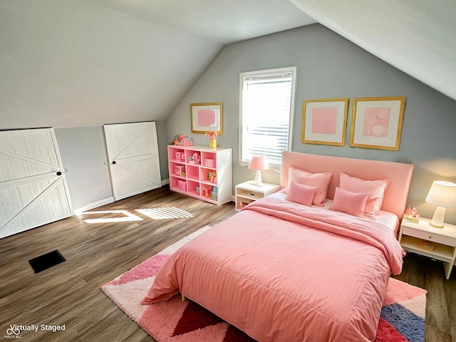 bedroom featuring baseboards, vaulted ceiling, and wood finished floors