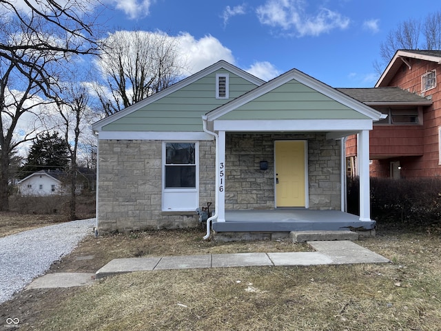 view of front of house with stone siding and a porch