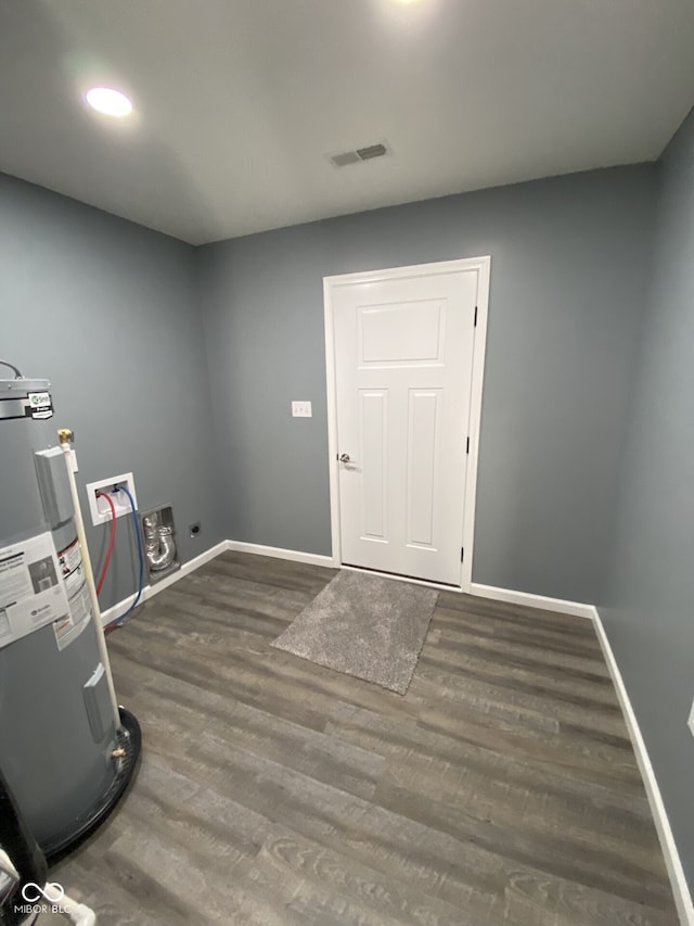 clothes washing area featuring laundry area, baseboards, visible vents, wood finished floors, and electric water heater