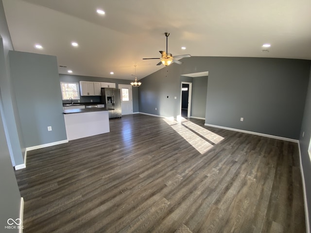 unfurnished living room with dark wood-type flooring, lofted ceiling, a sink, and baseboards