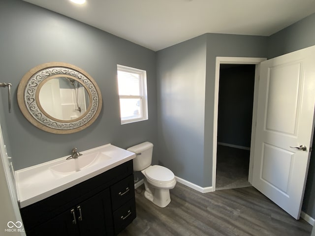 bathroom with baseboards, vanity, toilet, and wood finished floors