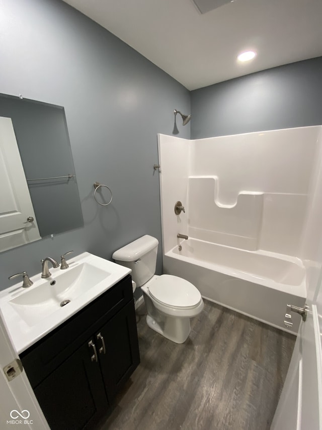 bathroom with toilet, bathtub / shower combination, wood finished floors, and vanity