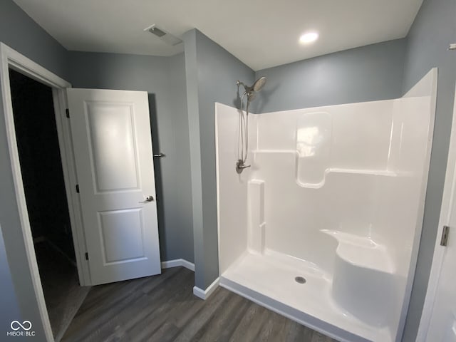 full bath with wood finished floors, visible vents, baseboards, and walk in shower