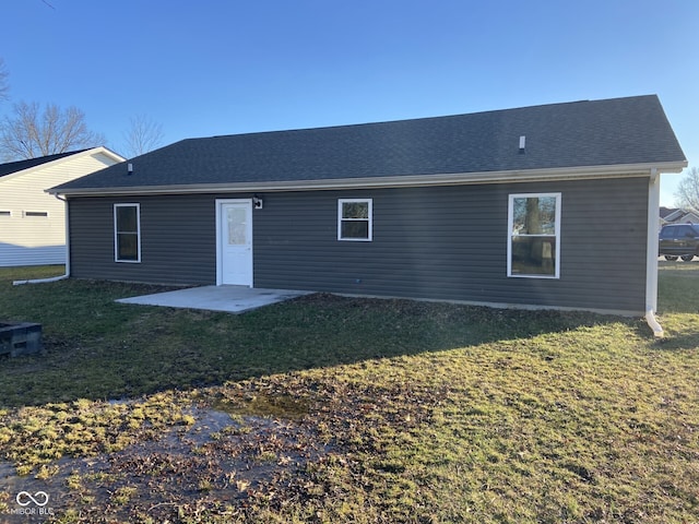 back of property with a patio area, a lawn, and roof with shingles