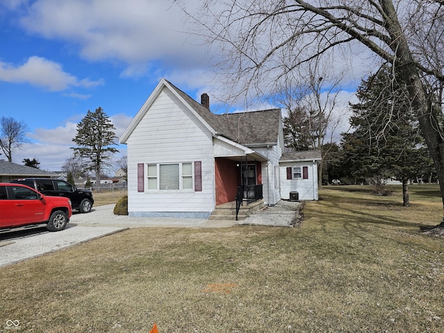 view of front facade featuring a front lawn and a chimney