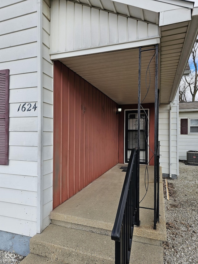 doorway to property featuring board and batten siding and central AC