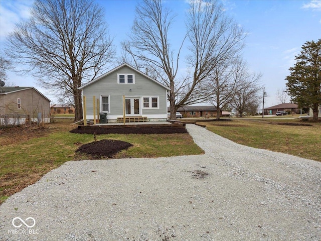 bungalow with french doors, driveway, and a front lawn