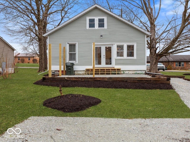 view of front facade with entry steps, french doors, and a front yard