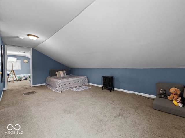 unfurnished bedroom featuring carpet floors, visible vents, baseboards, and vaulted ceiling